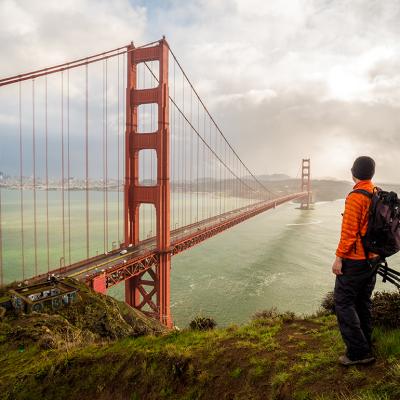 A hiker-traveler looking at the famous Golden Gate Bridge in San Francisco, USA.