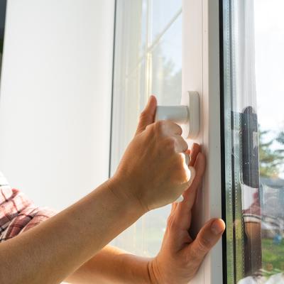 A person opening a glass home window in the morning.