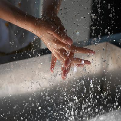 Person washing hands over a sink.