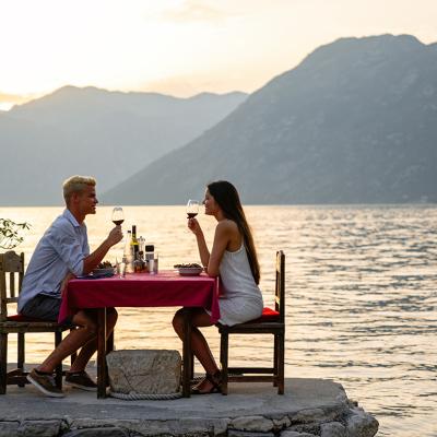 A young couple enjoying a romantic dinner by the beach.