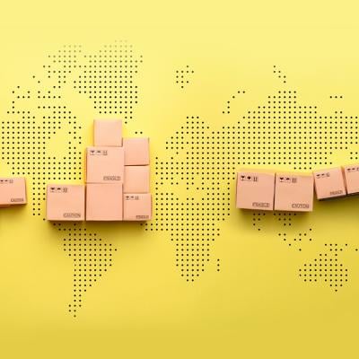 A loader loads goods into a truck against the backdrop of a world map.