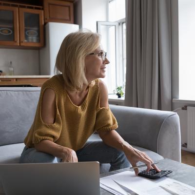 A female homeowner in deep thought while calculating home expenses.