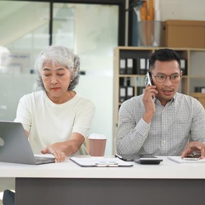 Co-business owners separately talking with customers using different devices.