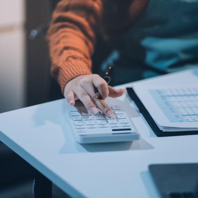 Worker calculating finance reports using a calculator.