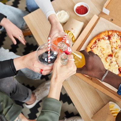 People raising their glass beverages while celebrating at home.