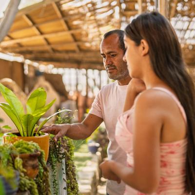 A couple checking and purchasing plants at a local garden store.