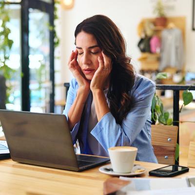 A female professional experiencing headache while working.