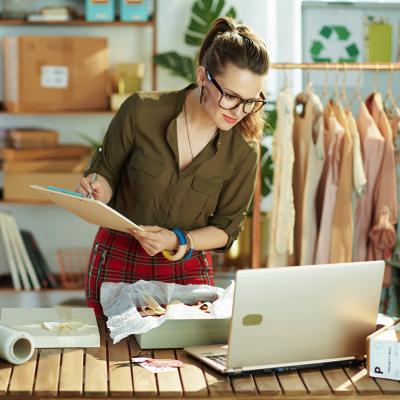 A female small business owner checking a customer's order from a laptop.