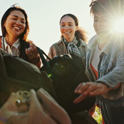 An excited group of friends packing their bags for a roadtrip.