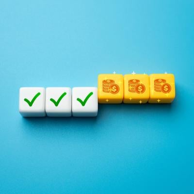 A die set with half showing a green check symbol and the other half are coin icons as a concept of incentive strategy.