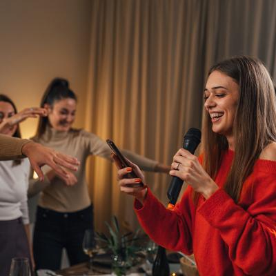 A young woman sings karaoke at a house party.