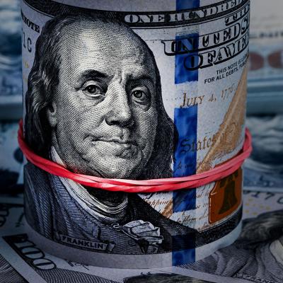 Close up on a rolled band of US dollar banknotes.