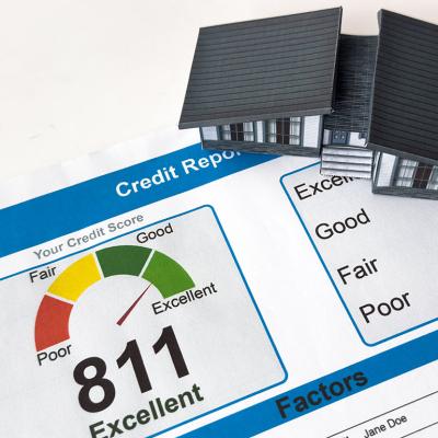 A small figure of a house on top of a credit score report.