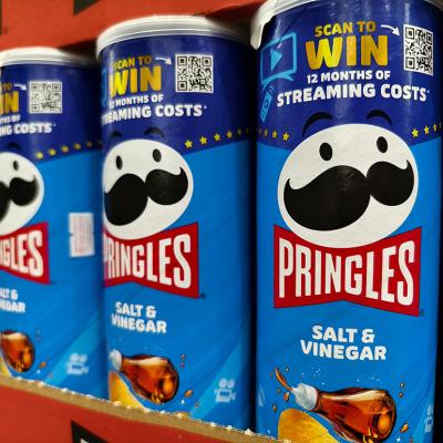 Cans of Pringles on a shelf featuring a QR code for a contest.