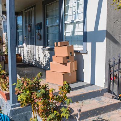 Delivery packages piled up on a front porch.