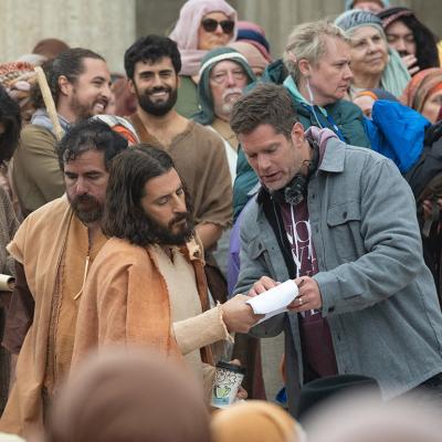 Directory Dallas Jenkins on set surrounded by actors dressed in costume for a scene of season 5 of The Chosen.