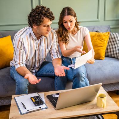 A young couple at home discussing bills.