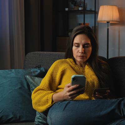 A middle-aged woman at home purchasing online using her credit card.