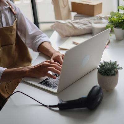 A cafe owner managing online orders from a laptop.