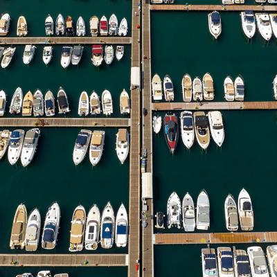An aerial view of anchored yachts and boats at the docks in a marina.