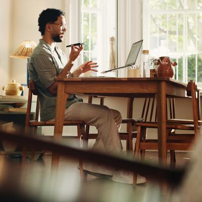 A businessman working from home and talking on the phone.