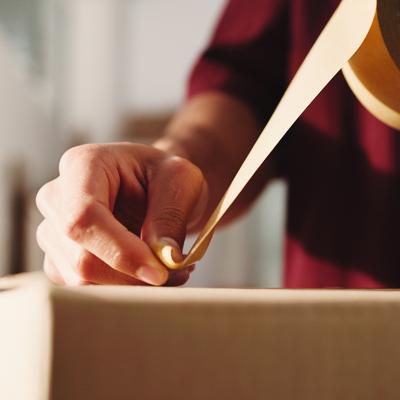 Person taping over a package for shipping.