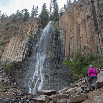 A senior woman at the base of Palisade Falls in Montana.