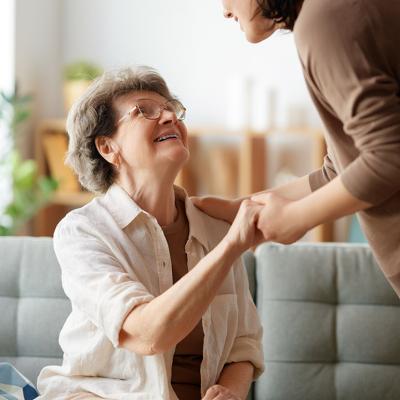 An elderly patient with her caregiver sharing a conversation with each other.