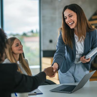 Two businesswomen concluding a meeting with a handshake.