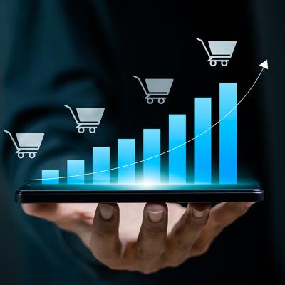 Person holding a device projecting a digital bar chart depicting growing sales.