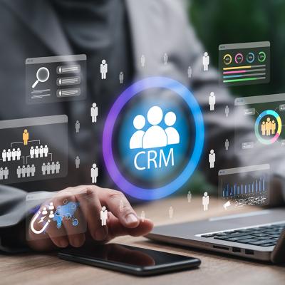 CRM automation graphics over a businessman using a laptop and phone for work.