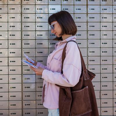 A woman sorting through her letters from the mailbox.