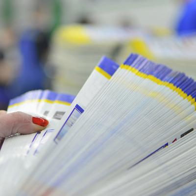 Person checking pages of printed paper.