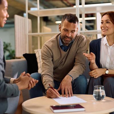 A couple meeting with a financial advisor for an insurance's contract signing.