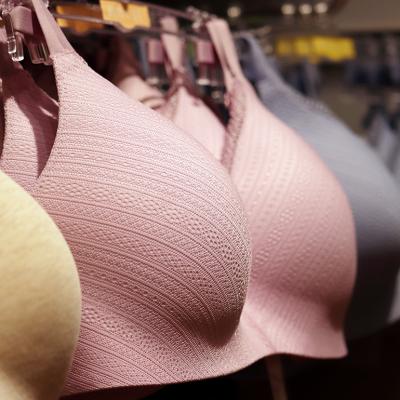 Different sizes and colors of wireless bras on a lingerie store rack.
