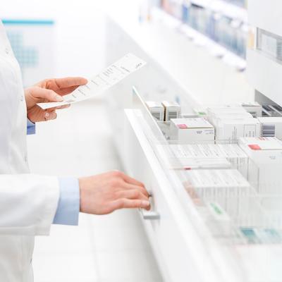 A pharmacists filling out a prescription in a pharmacy.