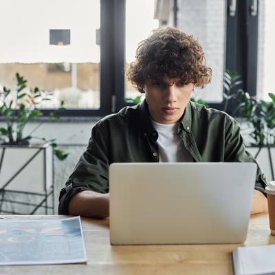 A young man working with a laptop in a stylish office.