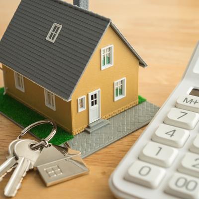 A small house model, house keys, and a white calculator as a concept of calculating rent.