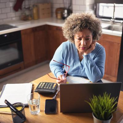 An entrepreneur reviewing budget, expenses, and payments of her business from a laptop.