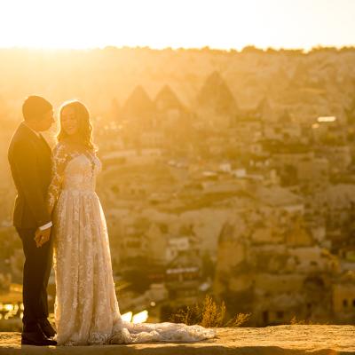 A couple poses for a sunset wedding photograph in their venue in Cappadocia, Turkey.