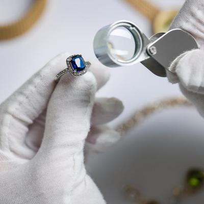 An appraiser inspecting a blue diamond ring.