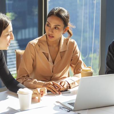 A small group of employees discussing work-related matters during a meeting.