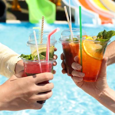 A group of friends putting up their drinks together beside a pool.