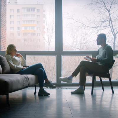 A doctor and a patient undergoing through a therapy session indoors.