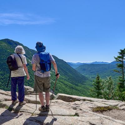 Hikers looking at the scenic view of the Crawford Notch from Mt. Willard in Carroll Country, New Hampshire, USA.