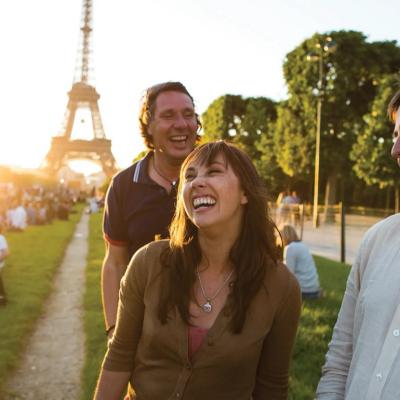 A group of friends enjoying an afternoon outdoors in front of the Eiffel Tower in Paris, France.