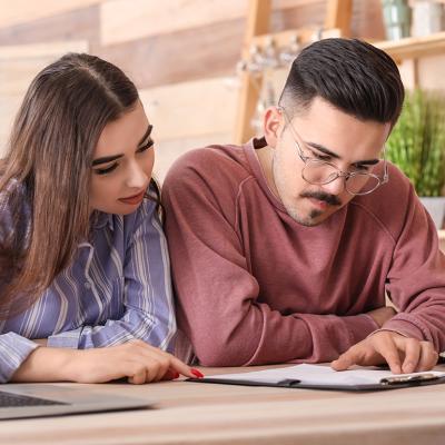 A young couple reviewing an insurance contract in a cafe.