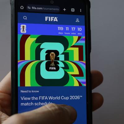 Person scrolling through a FIFA World Cup 2026 news article on a phone.