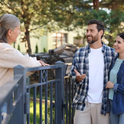 A young couple talking to a friendly elderly neighbor.