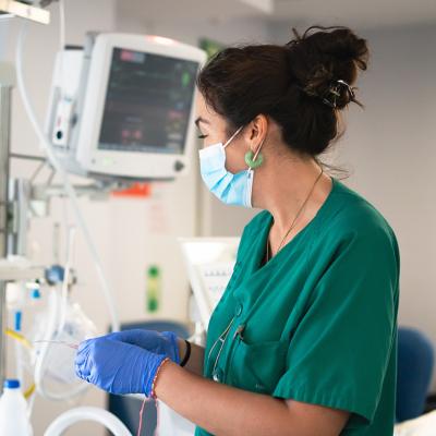 An ICU nurse working with medical monitors.